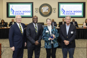 Photo of Arina Van Breda from the Fairfax League of Women Voters with George Mason University President Gregory Washington, Rector Michael Meese, and John Wood at the 2026 Jack Wood Award celebration.