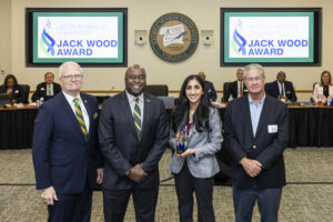 Photo of Iman Chaudry from Mason Consulting Group standing with George Mason University President Gregory Washington, Rector Michael Meese, and John Wood.